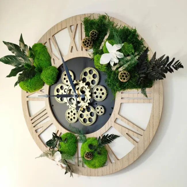 Horloge végétale design 57 cm sans encadrement, mousses stabilisées fougères feuillages et fleurs naturelles, mécanisme à engrenages dorés et aiguilles quartz – création artisanale française unique, livraison France
